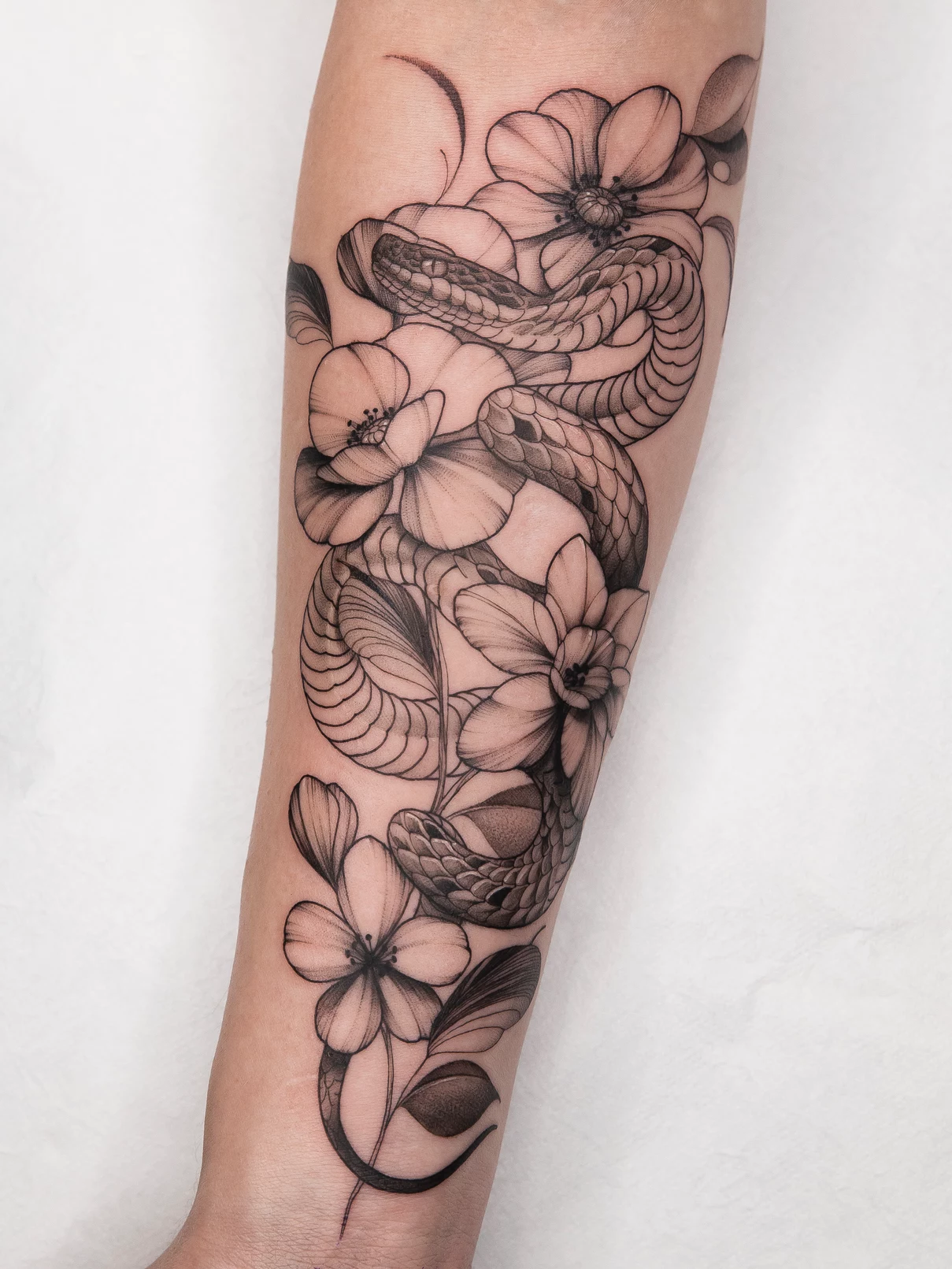 Tatuaje Dotwork-Blackwork serpiente con flores Mamba Negra