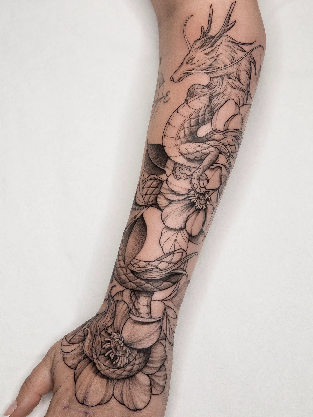 Tatuaje Dotwork-Blackwork dragón y flores Mamba Negra