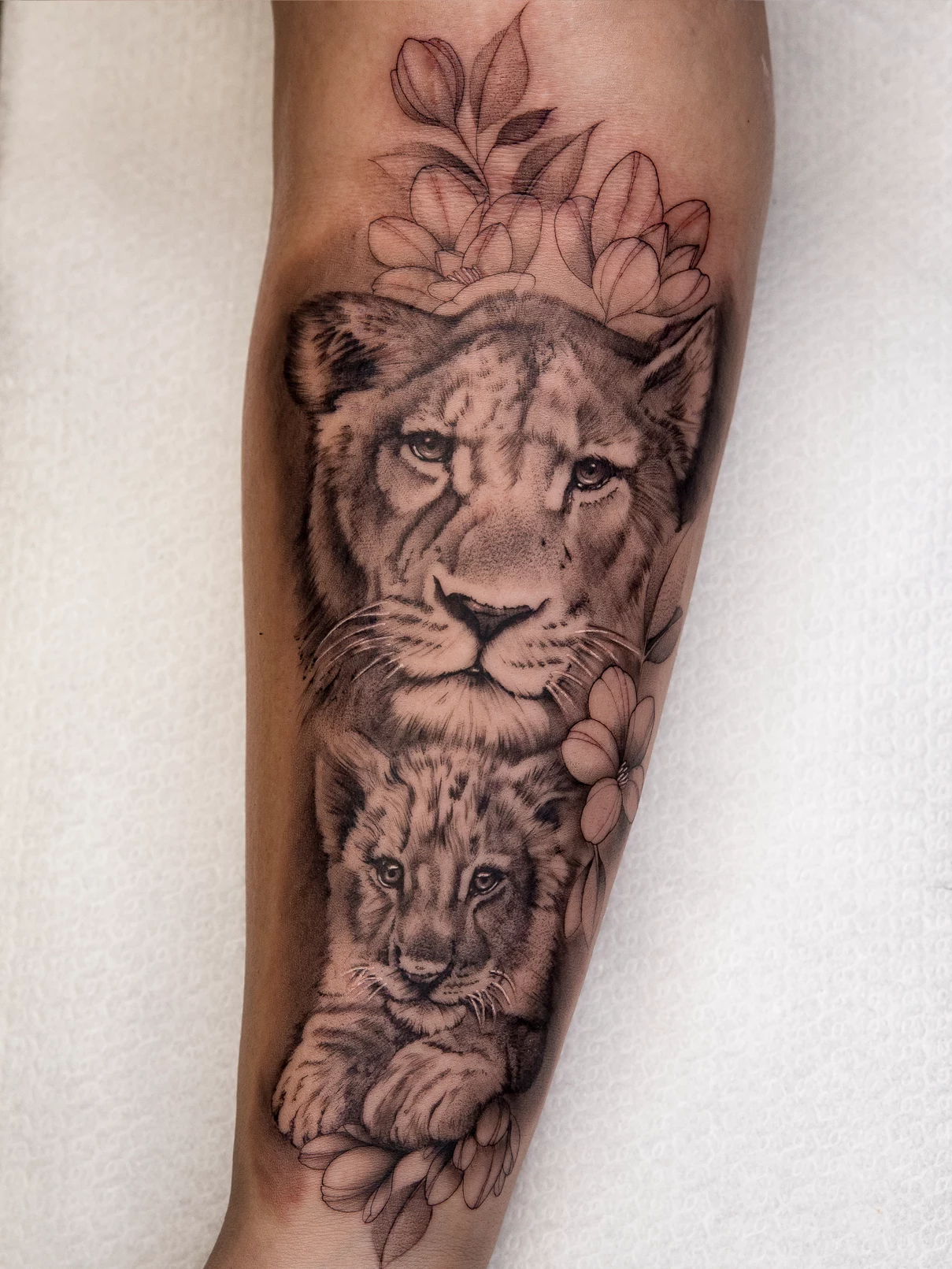 Tatuaje realista leona y cachorro Mamba Negra
